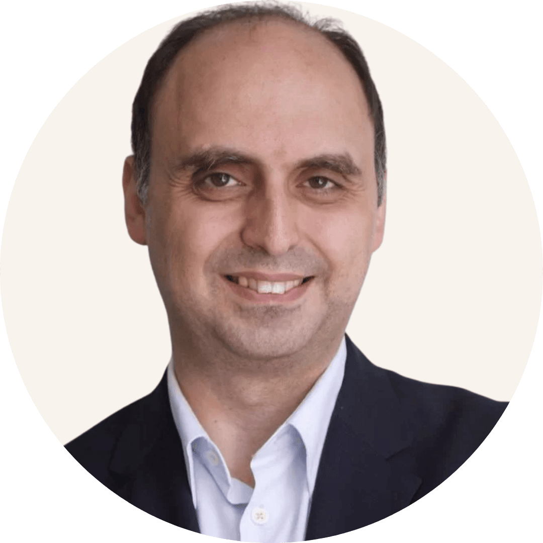Dr Hani Dajani smiling, with receding dark hair, wearing a dark suit jacket and a light blue shirt