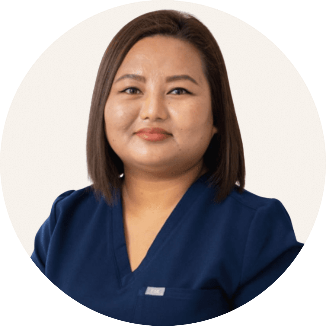 Dimple Gurung, with shoulder-length dark hair, wearing navy scrubs