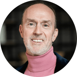 Dr Gareth Morris-Stiff smiling, wearing a pink roll-neck jumper and a dark jacket