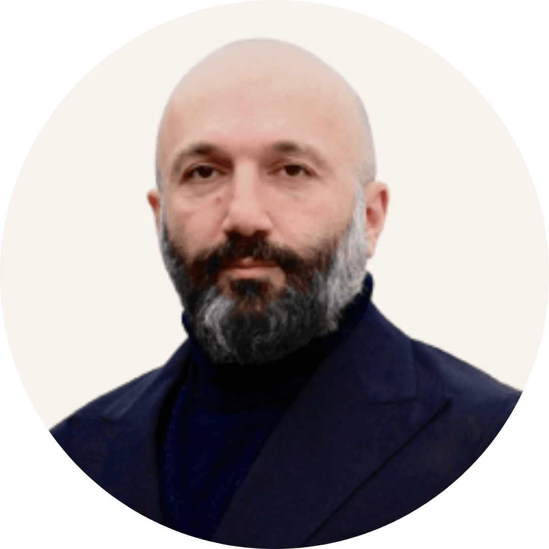 Dr Hossein Rostamipour of Eton Psychologists, with a shaved head and a greying beard, wearing a dark roll-neck and a jacket