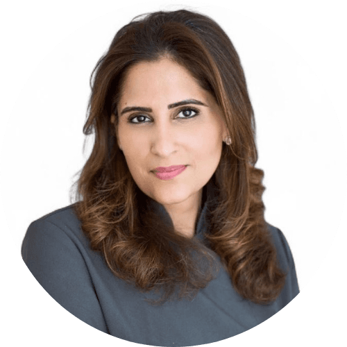 Rakhee Mediratta, with long brown hair, wearing a grey jacket