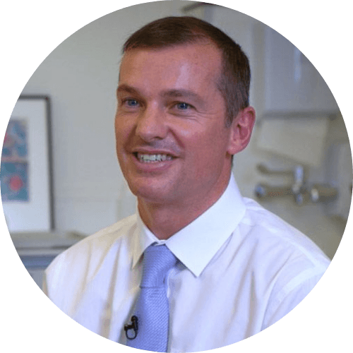 Ian Lilly smiling, wearing a white shirt and a light blue tie